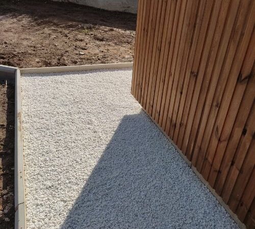 Allée gravillonnée avec bordure béton et bardage bois