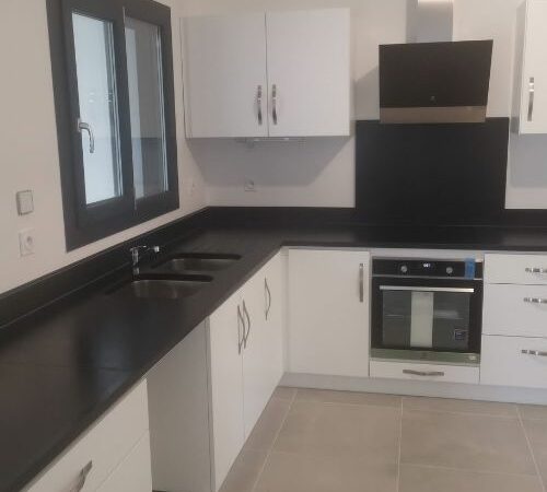 Cuisine moderne en angle avec plan de travail noir