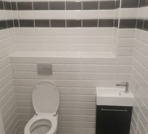 WC suspendu avec carrelage mural blanc et noir